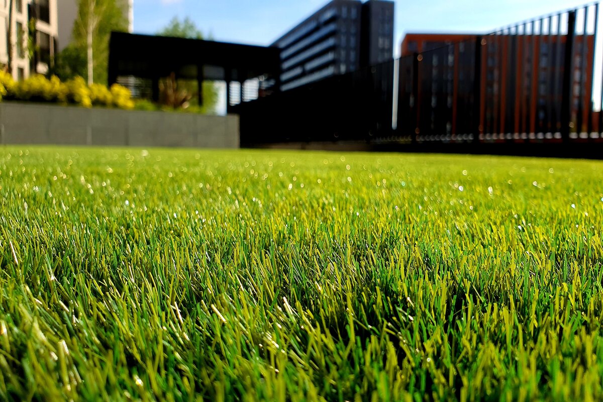 How Much Does Artificial Grass Cost in 2026? Text: Artificial Grass Cost | Background Image: Artificial Grass Lawn