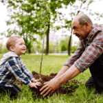 Why Fall Is the Best Time to Plant Trees and Shrubs A child helps his grandfather plant a tree in their yard
