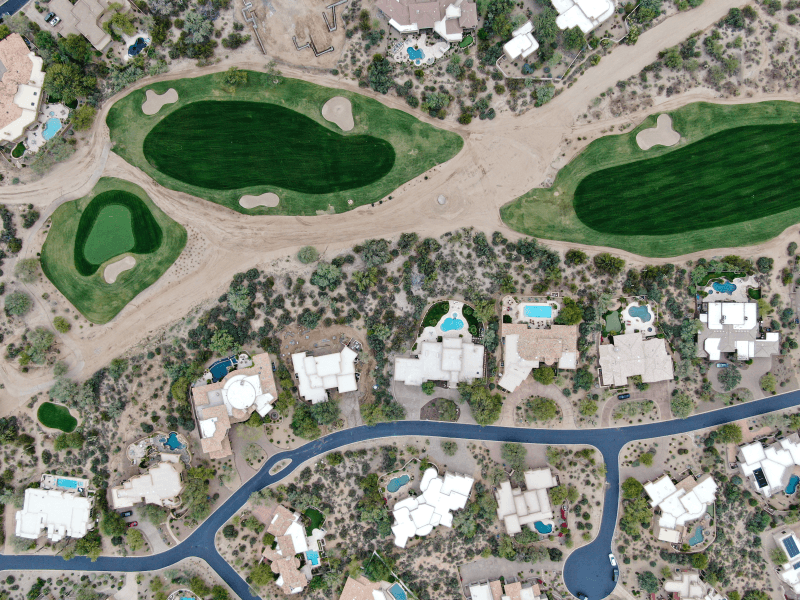 An aerial view of a neighborhood in Scottsdale, Arizona, with backyard pools and a nearby golf course green