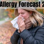 Fall Allergy Forecast 2026: Where Pollen Will Hit Hardest This Year A blonde woman in a black puffer jacket and brown knit scarf sneezes into a white tissue while standing on a tree-lined path surrounded by colorful fallen autumn leaves, with the text "Fall Allergy Forecast 2026" overlaid at the top.